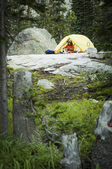 Woman camping near Crater Lake at the base of Lone Eagle Peak, Indian Peaks Wilderness, Colorado, USA
