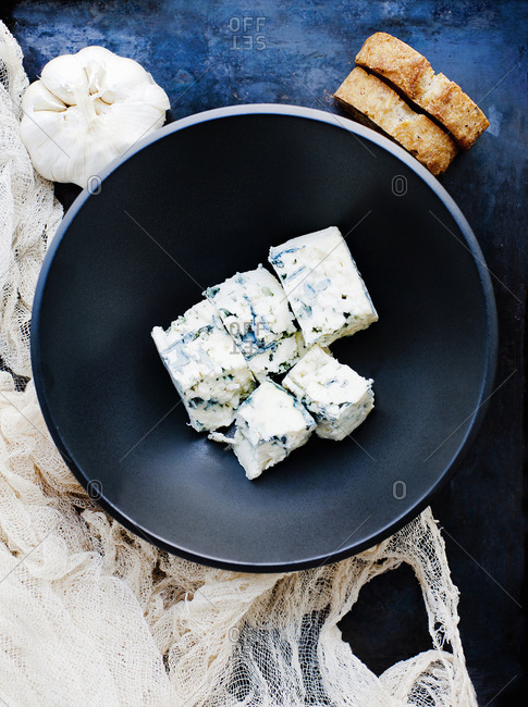 Garlic bulb and bowl of cubed blue cheese