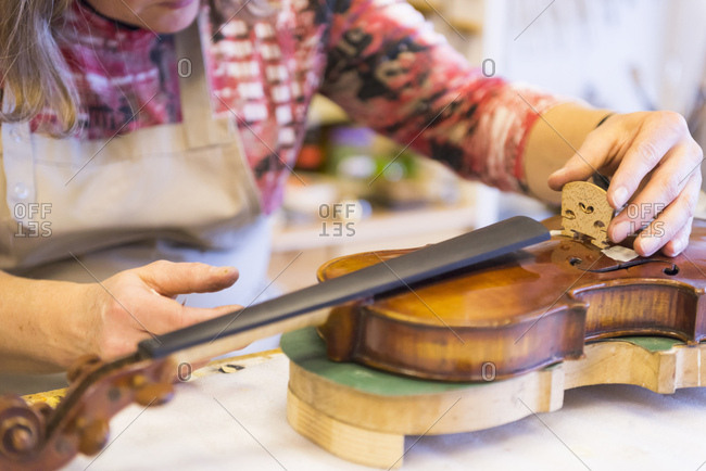 Violin maker making violins in production studio