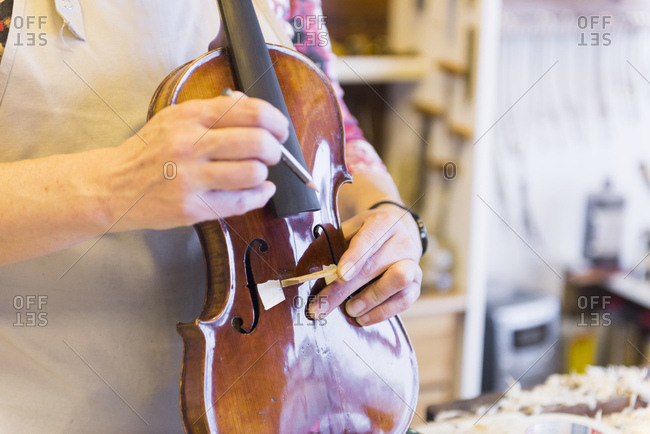 Violin maker making violins in production studio