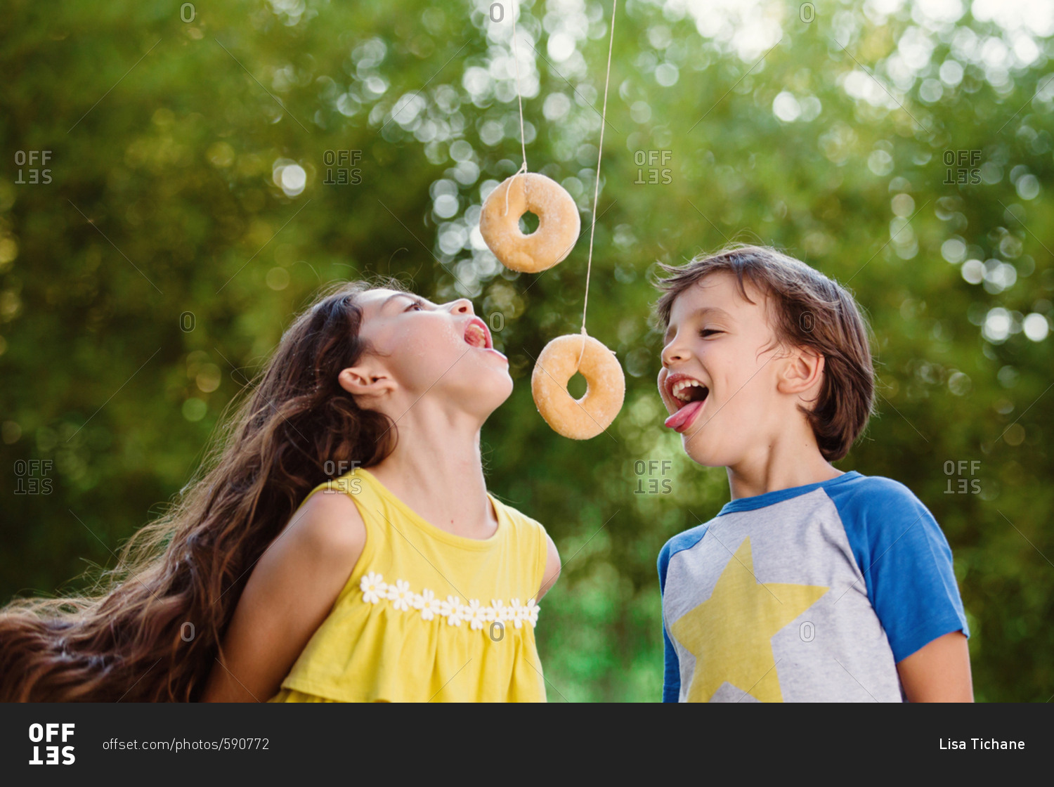 boy-and-girl-eating-donuts-on-strings-stock-photo-offset