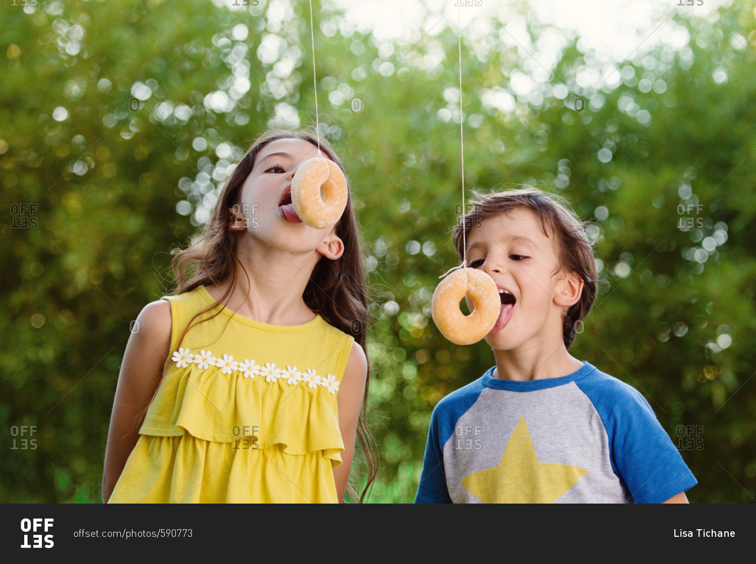kids-eating-donuts-on-strings-stock-photo-offset