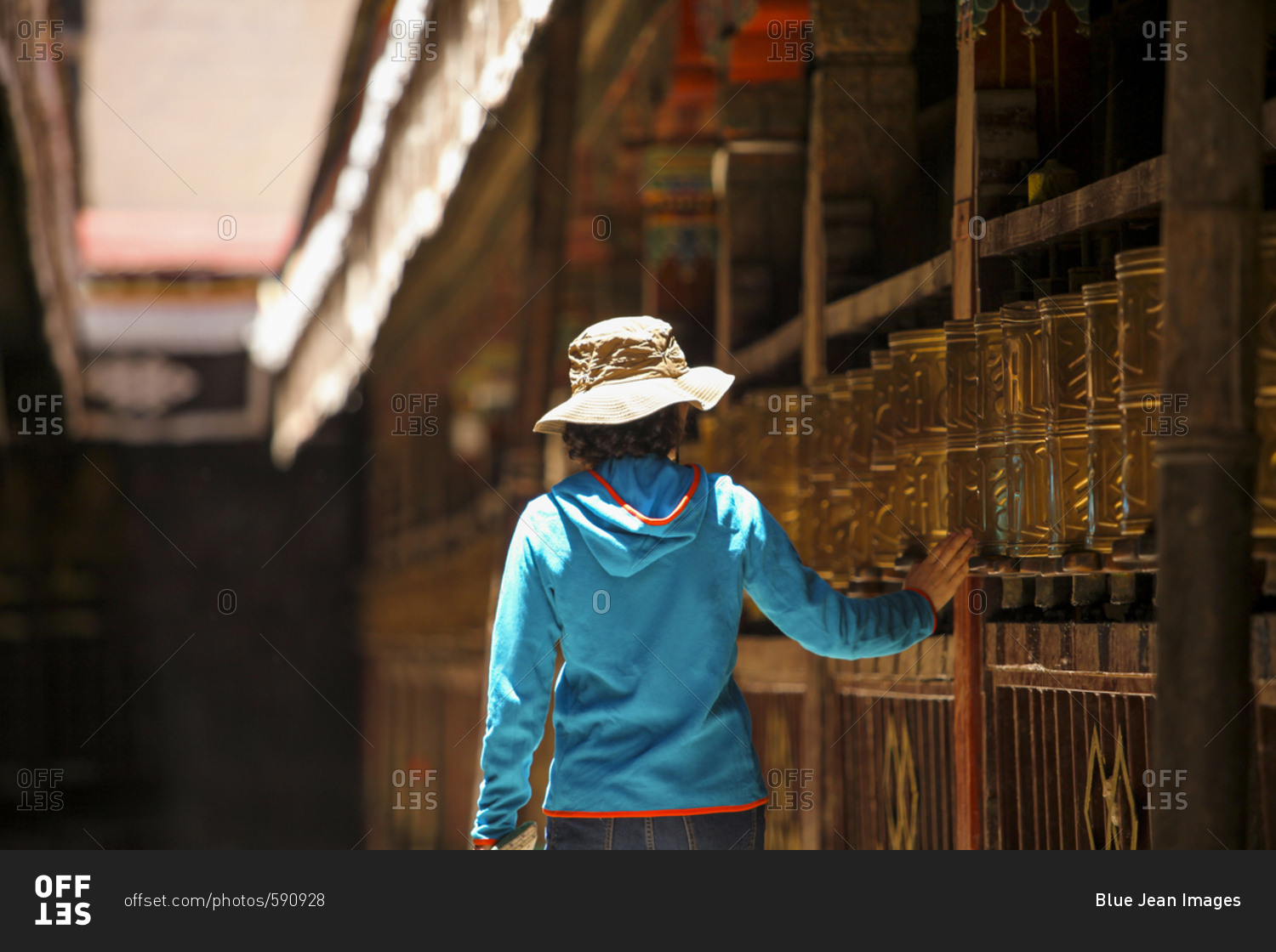 Tourist touching prayer wheel in Jokhang Temple stock photo OFFSET