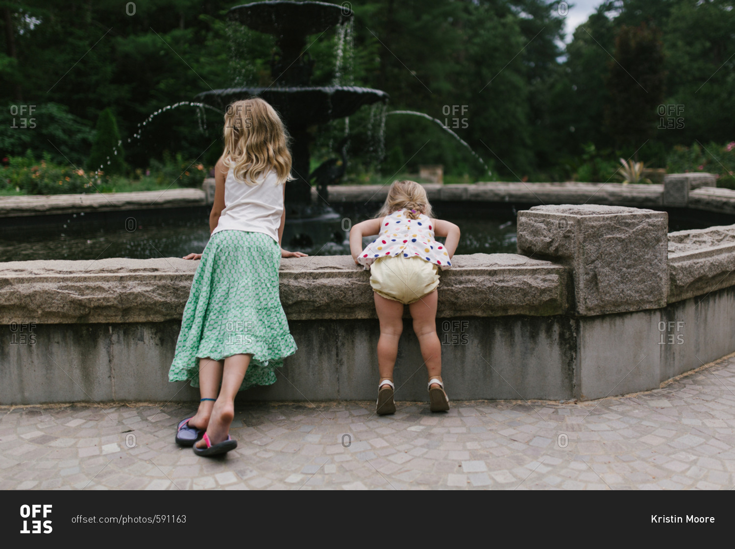 Girls by fountain in garden