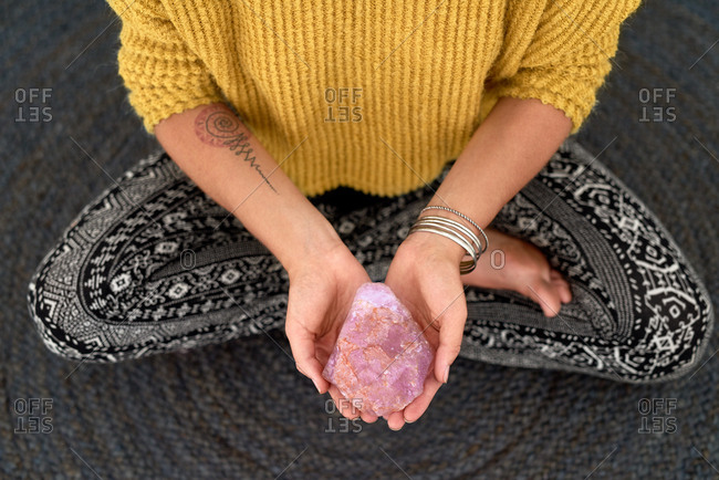 Spiritual woman's hands holding quartz crystal