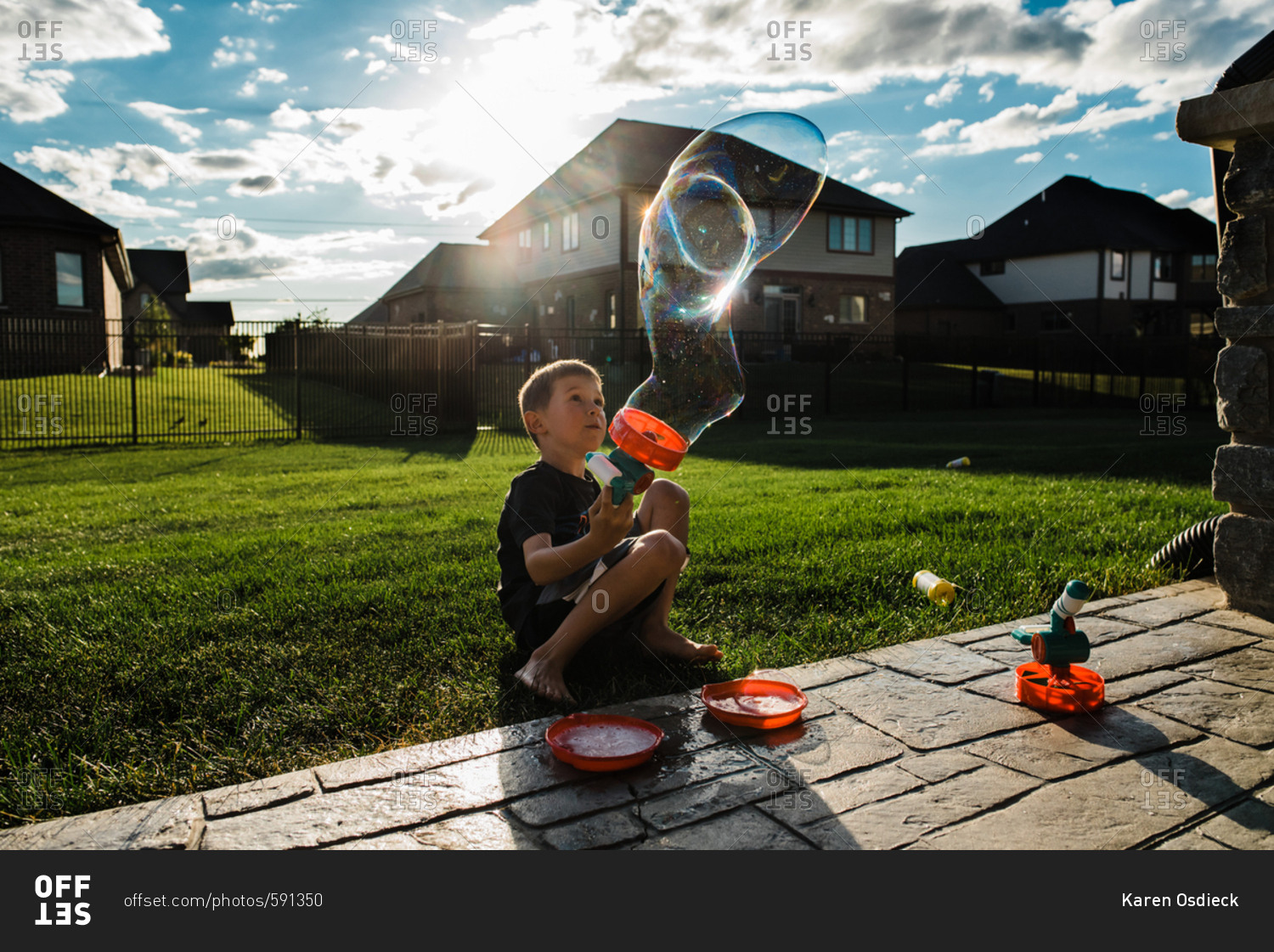 Boy playing with a bubble gun in a backyard