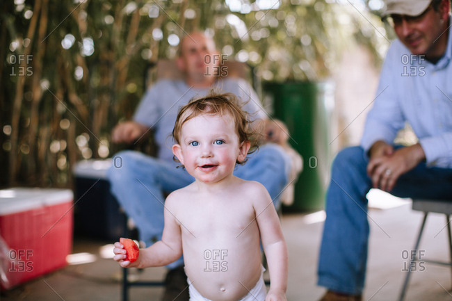 A toddler eating watermelon