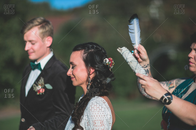 Alternate bridal couple at spiritual wedding ceremony outdoors, ceremony, feather, half portrait