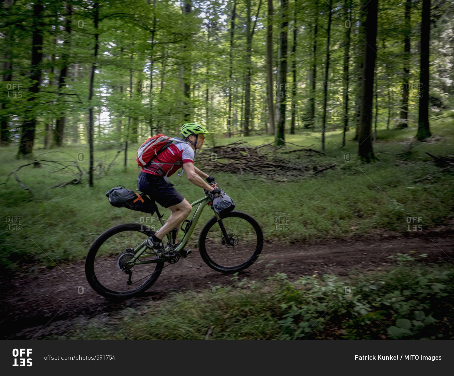 Mountain biker riding on a full suspension mountain bike through forest