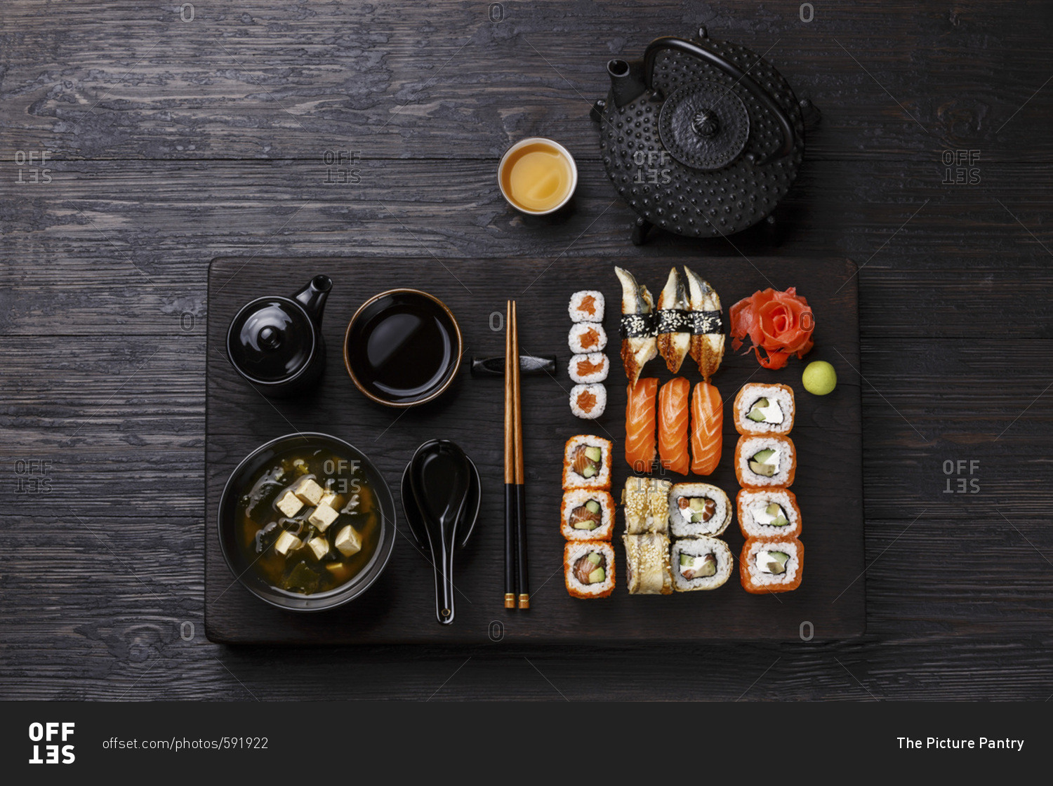 Sushi Set nigiri and sushi rolls and Miso Soup with tofu on wooden serving board block on black background
