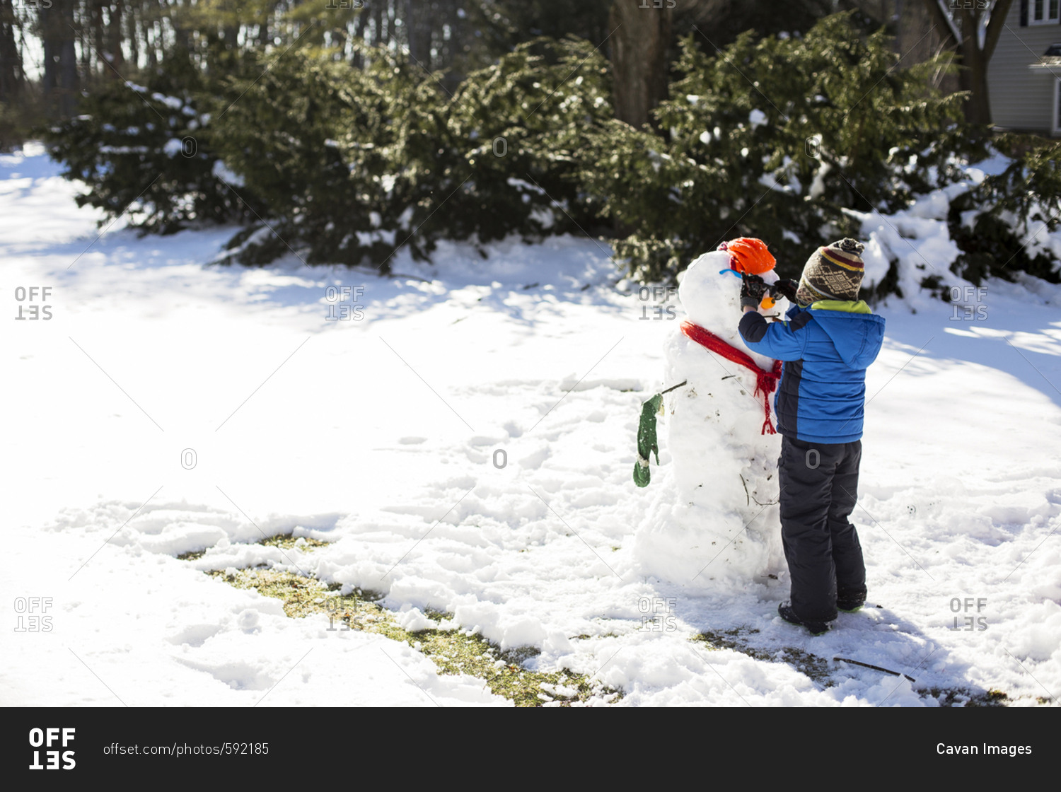 Boy making snowman on snowy field