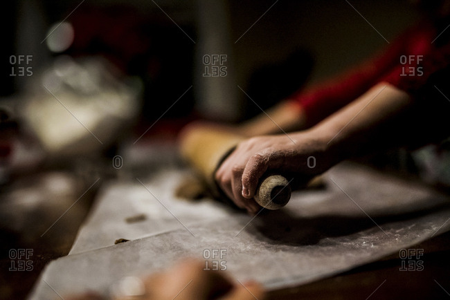Cropped image of girl rolling dough in kitchen