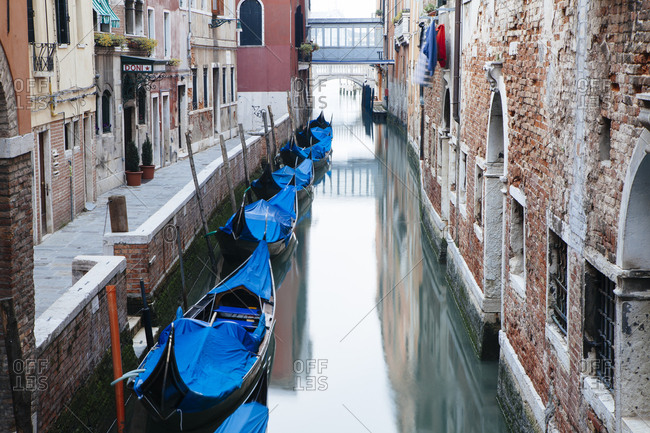 Venice, Italy - May 8, 2010: Covered gondolas on a canal in Venice Italy