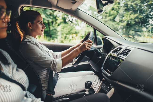 Woman driving a car with friend in front seat