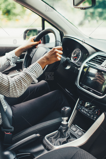 Woman driving a car on with manual transmission stock photo - OFFSET