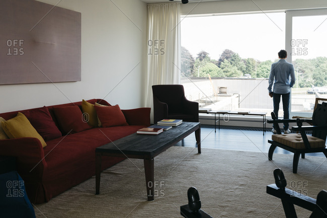 Antwerp, Belgium - June 2, 2017: Man in a living room in a home in Kanaal development in Antwerp, Belgium