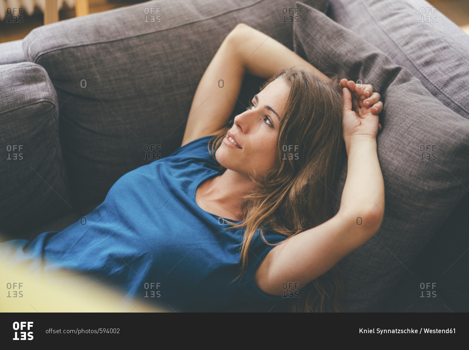 Relaxed young woman lying on couch at home