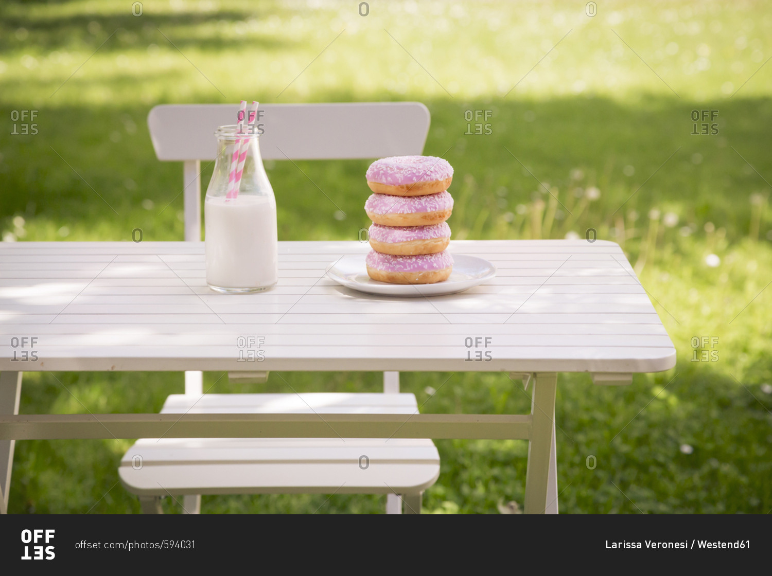 Stack of donuts and milk bottle on garden table