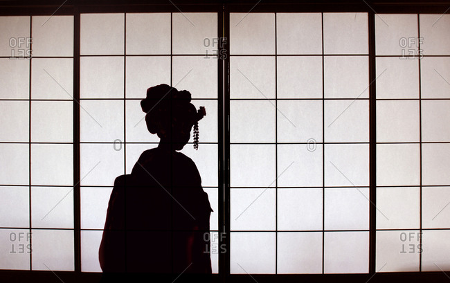 Silhouette of a geisha against shoji screen