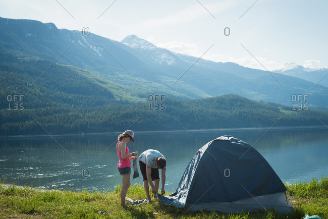 Couple putting up a tent in countryside on a sunny day