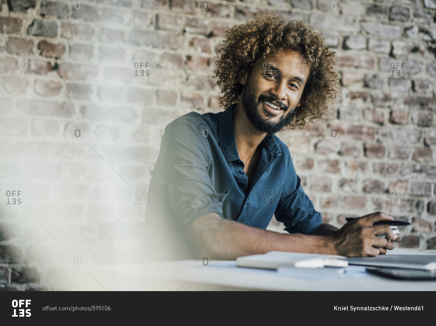 Portrait of smiling young man at desk