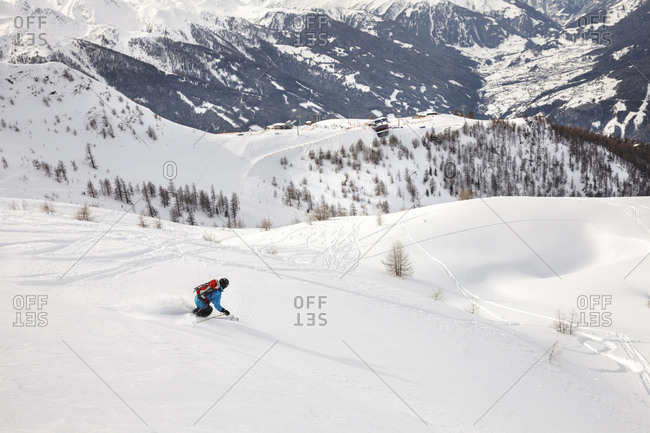 Man snowboarding downhill in powder snow