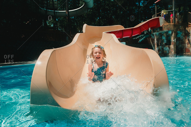 Little girl sliding down a water slide