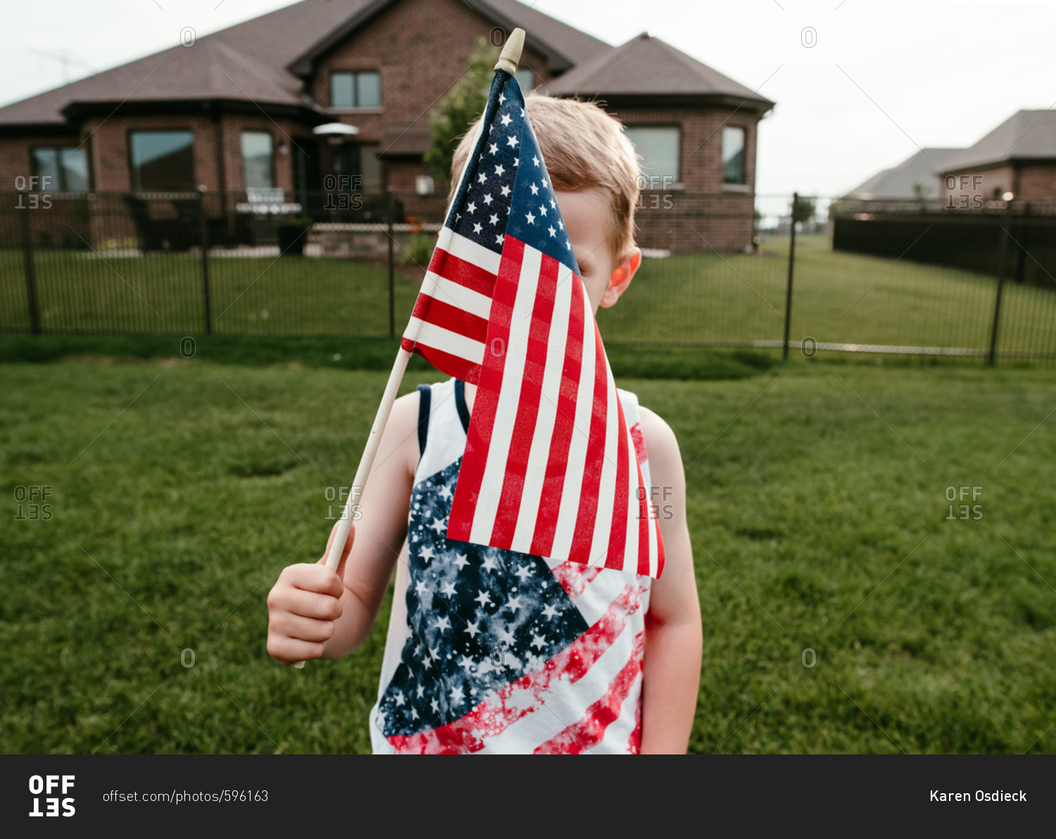 Boy holding an American flag in front of his face