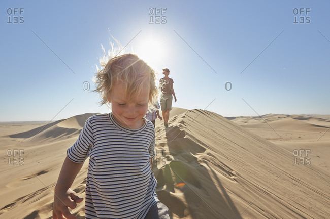 Mother and sons walking on sand dune, Dune 7, Namib-Naukluft National Park, Africa
