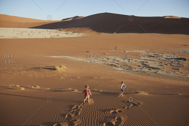Boys walking on sand dune, Namib Naukluft National Park, Namib Desert, Sossusvlei, Dead Vlei, Africa