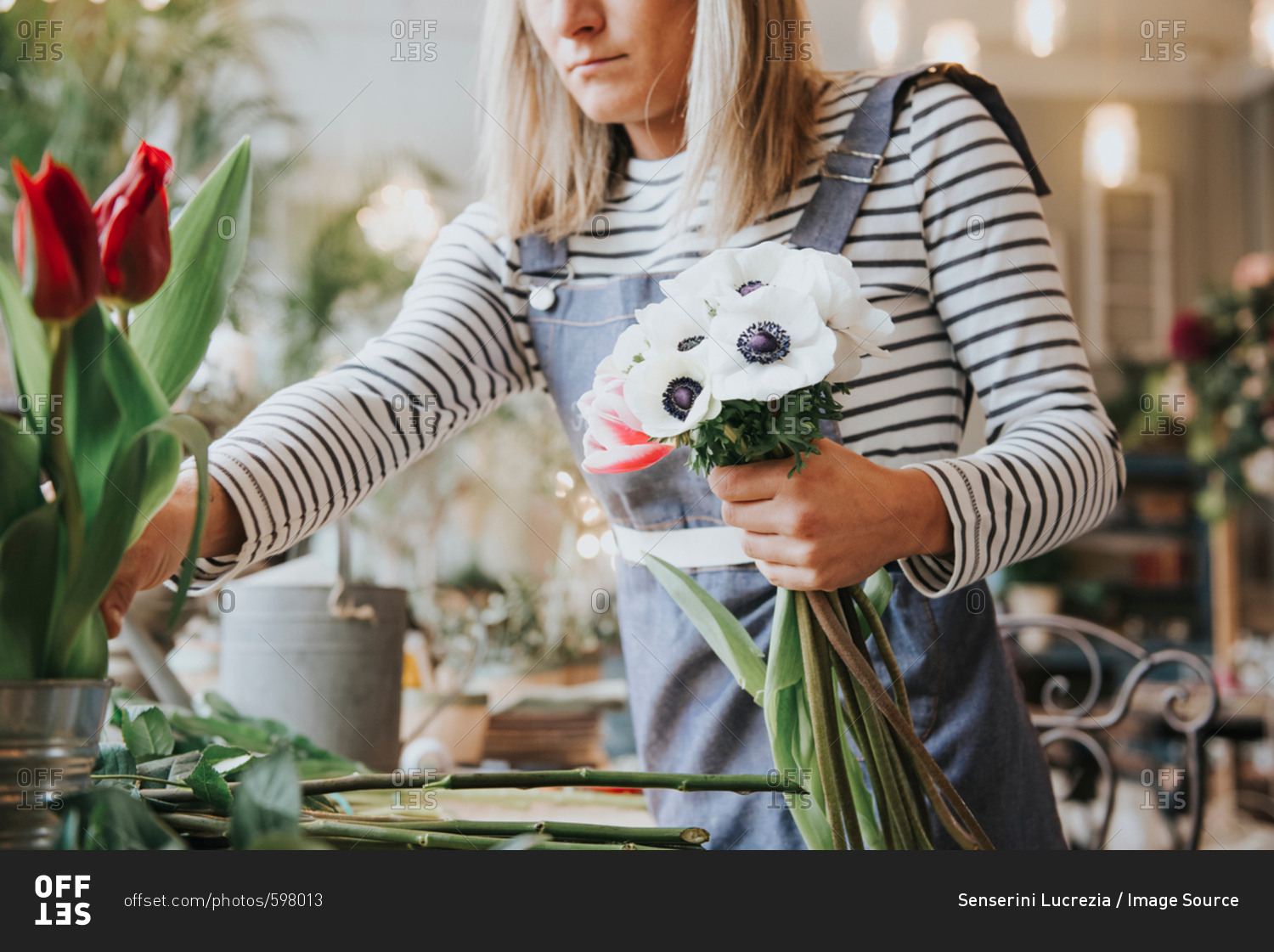 Florist in flower shop, preparing bouquet, mid section