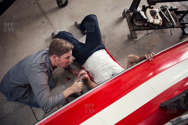 Overhead view of two men repairing in boat repair workshop