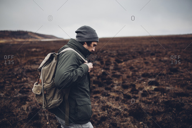 Side view of hiker carrying backpack while walking on barren landscape, Blagoveschensk, Amur, Russia