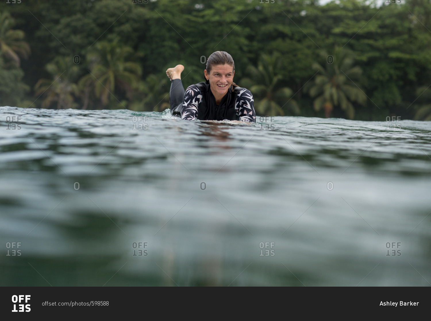 Woman paddling on surfboard in water at Bocas del Toro, Panama