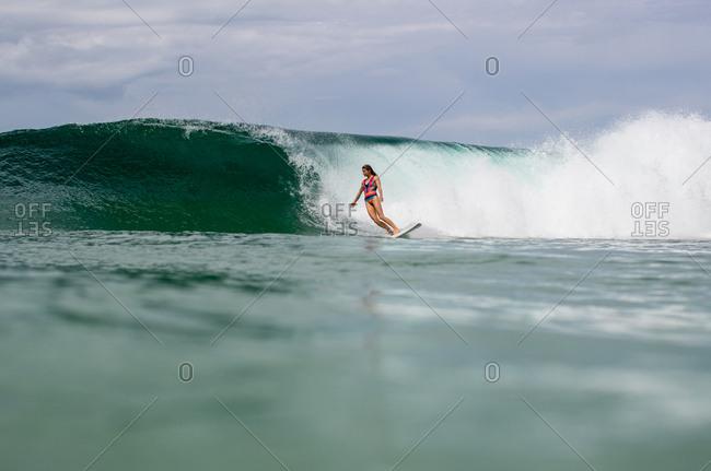 Woman surfing near wave on the tropical coast of Panama