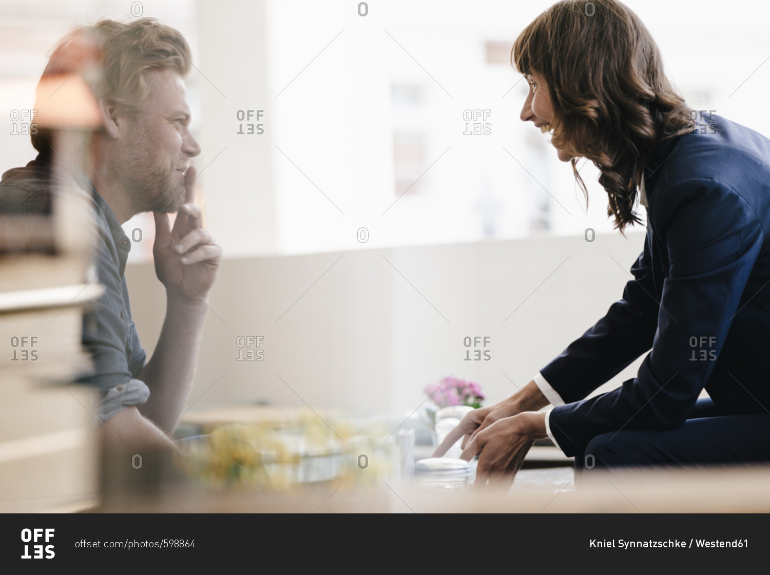 Man and woman sitting in cafe- discussing vividly
