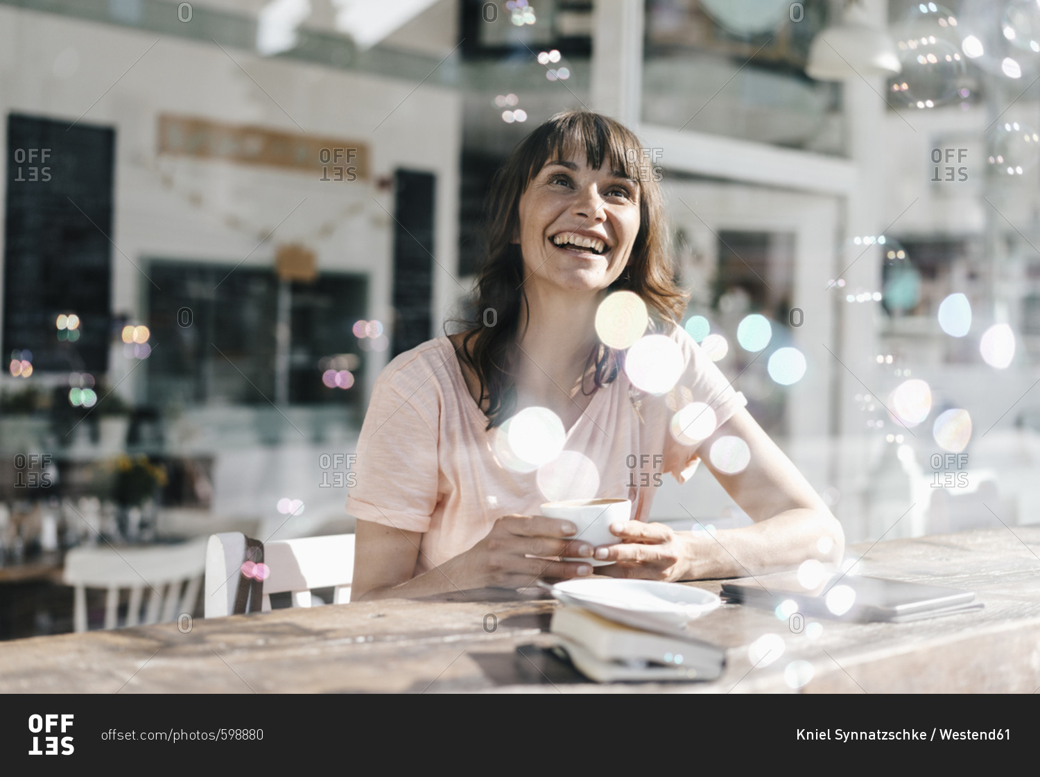 Woman sitting cafe- watching soap bubbles