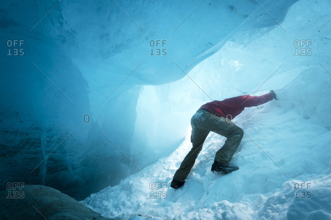 Low angle view of hiker ice climbing in cave