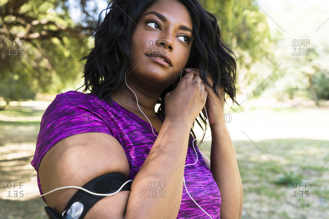 Woman wearing earphones while exercising at park