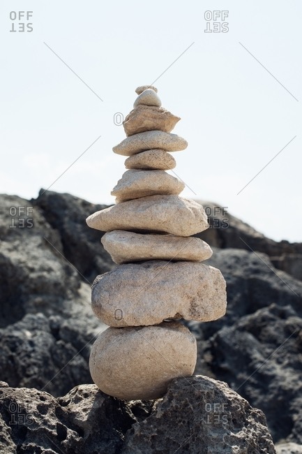 Light stone cairn stacked on a dark rocky surface