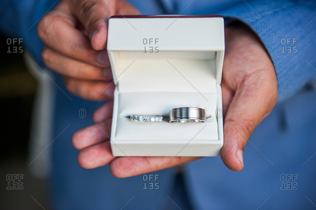 Groomsman holding a ring box with bride and groom wedding bands