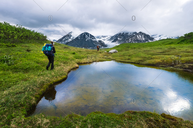 Group of backpackers walking in picturesque place on background of mountains