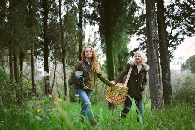 Mother and teenage daughter carrying picnic basket