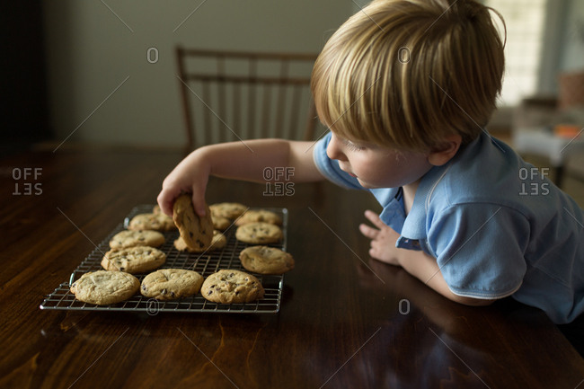 Boy grabbing cookie from cookie rack