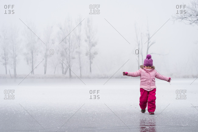 Little girl having some winter fun on the frozen lake