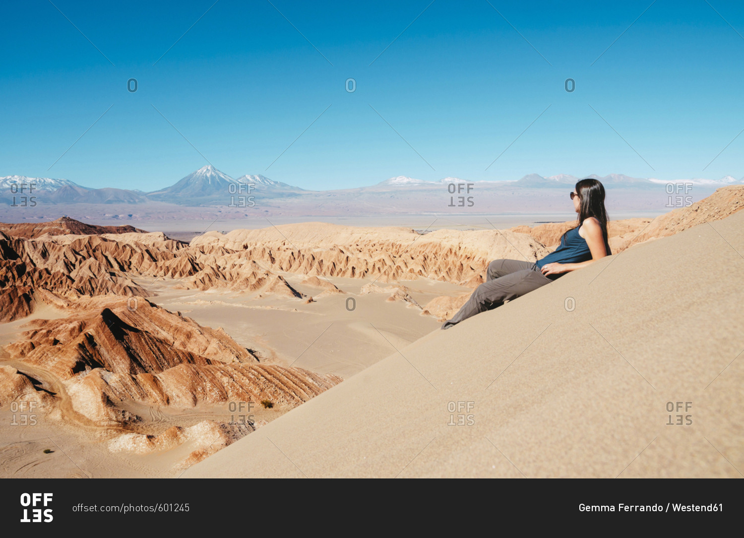 Chile- Atacama Desert- woman sitting on dune looking at view
