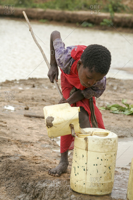 Kenya - July 17, 2009: Kenyan girl carries a jerrycan full of water on her head.