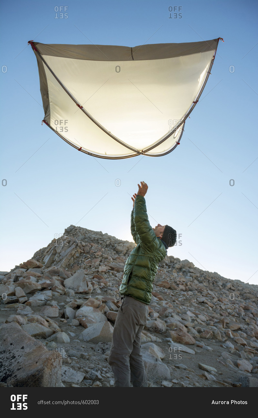 A man tossing his tent into the air while camping on Mount Fiske, Evolution Traverse, John Muir Wilderness, Kings Canyon National Park, Bishop, California