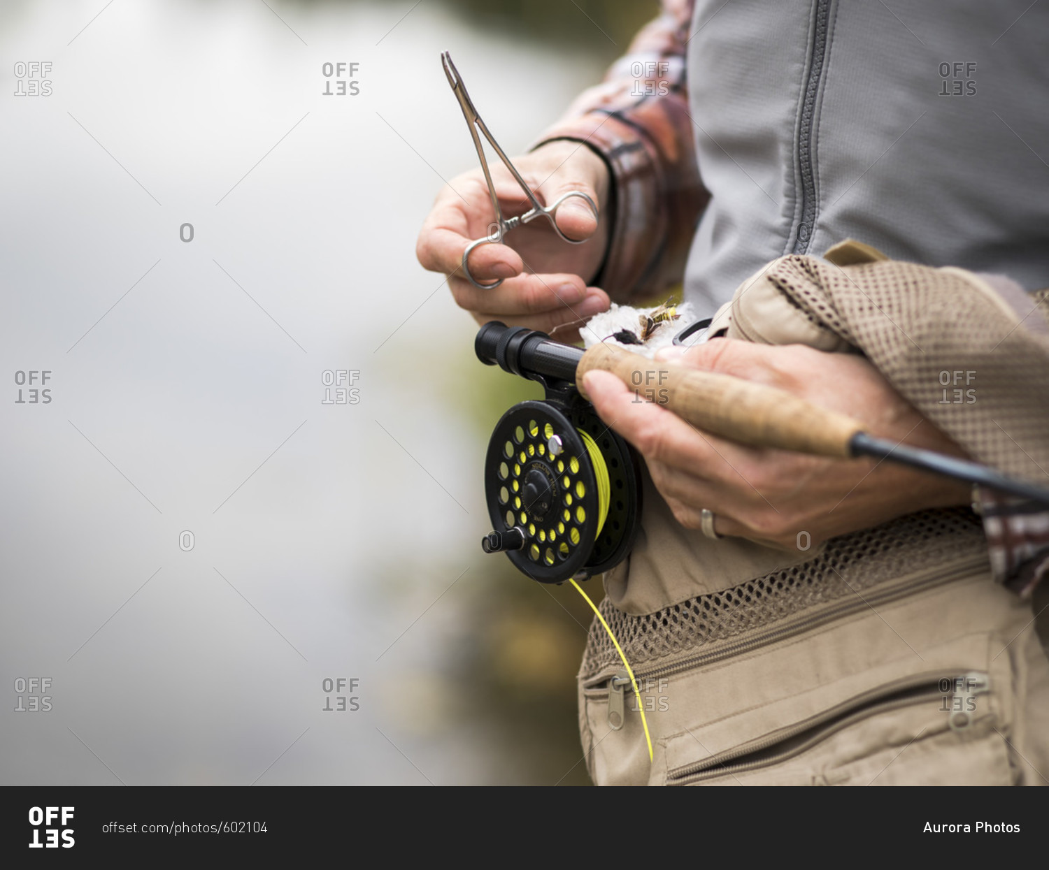 A man working on his fly fishing gear on the Payette River in Fall