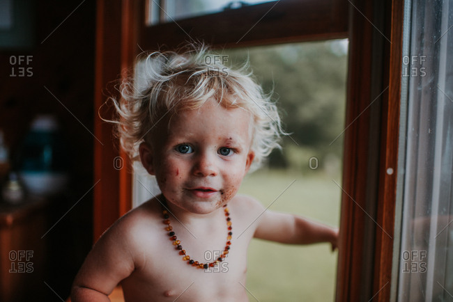 Blonde Toddler Boy With A Dirty Face Wearing Teething Necklace